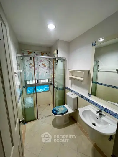 Modern bathroom with glass shower, stylish sink, and elegant decor