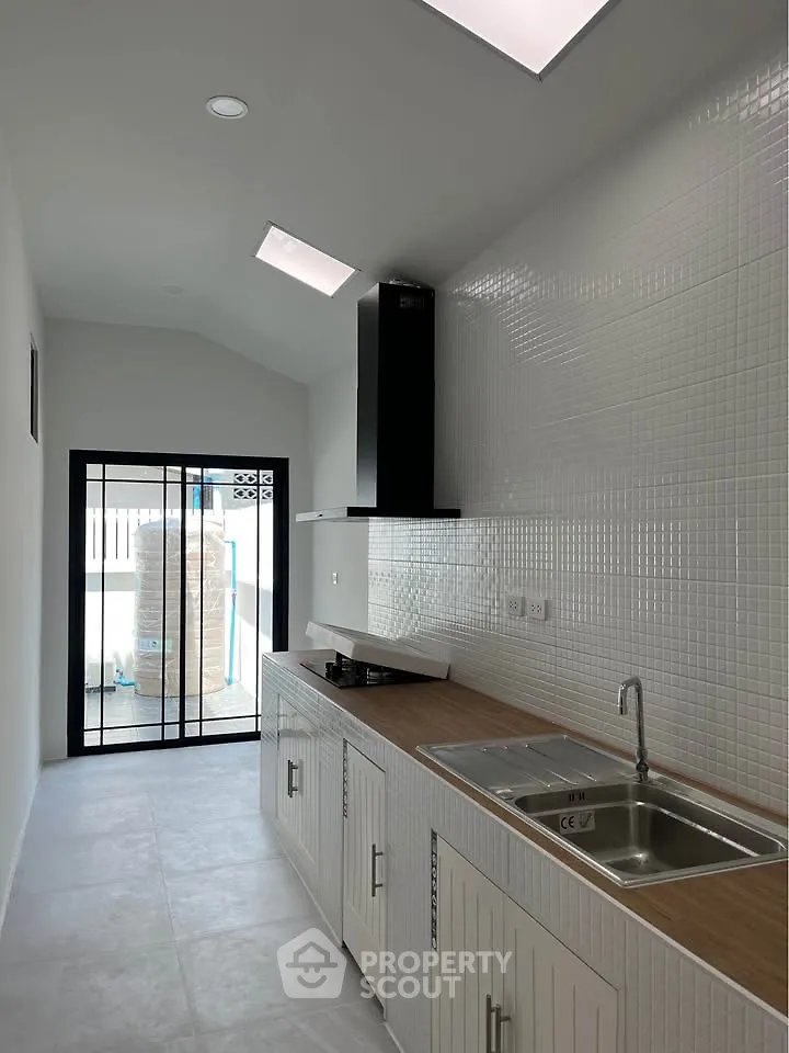 Modern kitchen with sleek design and natural light, featuring a gas stove and ample counter space.