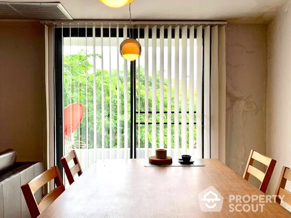 Bright dining area with large window and modern decor