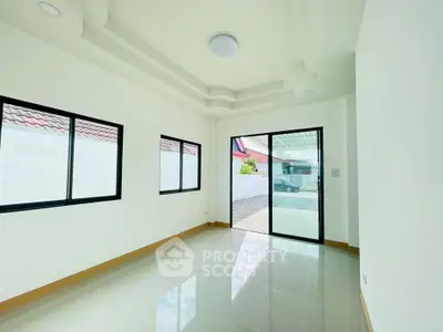 Spacious and bright room with large windows and modern ceiling design