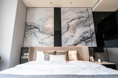 Luxurious modern bedroom with marble accent wall and elegant decor