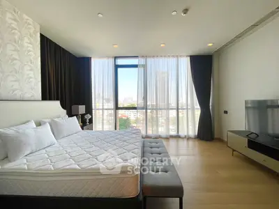 Spacious bedroom with city view, modern furnishings, and natural light
