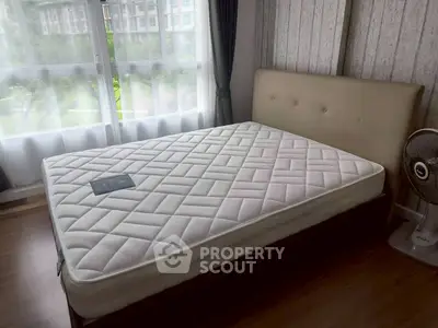 Spacious bedroom with large window and modern decor