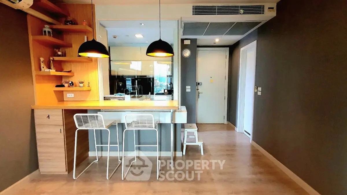 Modern apartment interior with stylish kitchen and dining area, featuring sleek design and contemporary lighting.