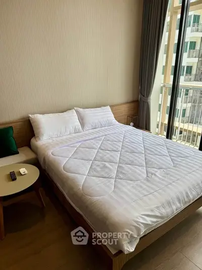 Modern bedroom with cozy bed and balcony view in a stylish apartment