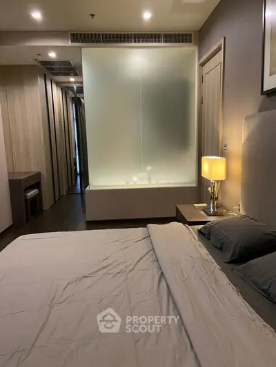 Luxurious bedroom with modern design and ambient lighting, featuring a cozy bed and elegant decor.