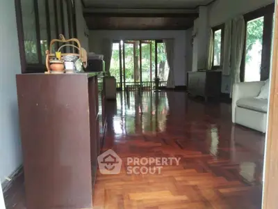 Spacious living room with polished wooden floors and garden view