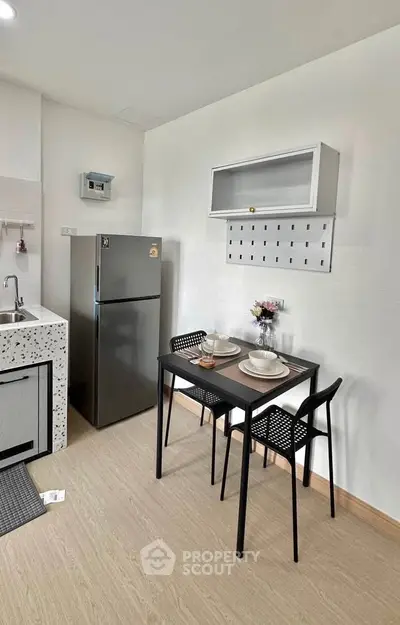 Modern kitchen with sleek fridge and dining area in a stylish apartment