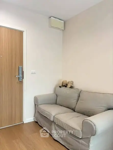 Cozy living room corner with a plush sofa and wooden door, perfect for relaxation.