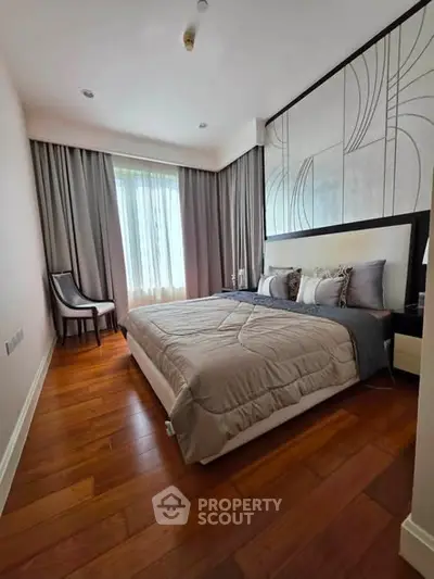 Elegant bedroom with modern decor and wooden flooring, featuring a large window with curtains.