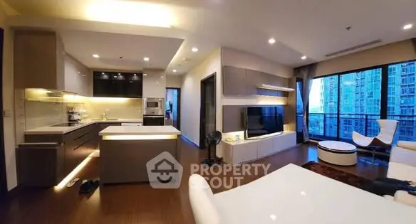 Modern open-layout living room with kitchen and city view balcony