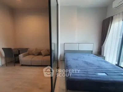 Modern bedroom with glass partition and cozy seating area