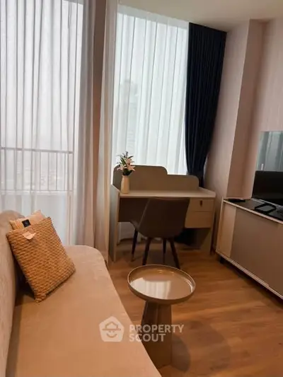 Modern living room with stylish furniture and large windows in a high-rise apartment.