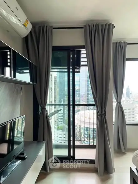 Modern living room with large windows and city view, featuring sleek furniture and elegant curtains.