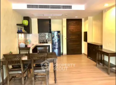 Spacious dining area with wooden furniture and open kitchen in modern apartment.