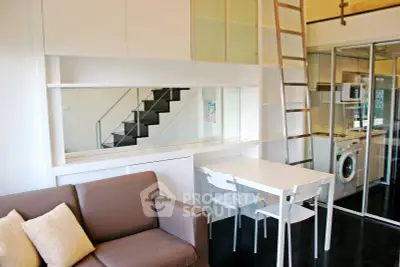 Modern loft apartment with sleek design, featuring a cozy living area, compact kitchen, and stylish staircase.
