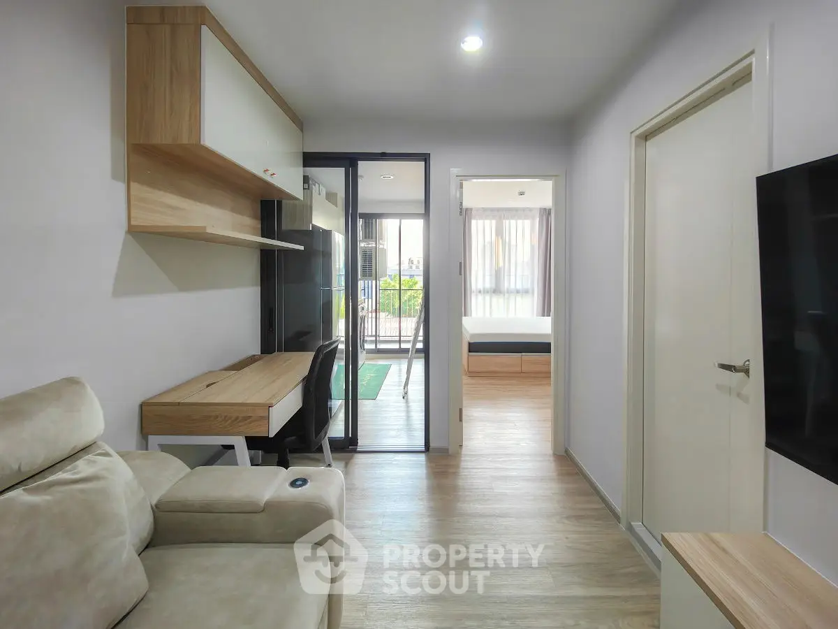Modern apartment interior with cozy living room and study area, featuring sleek furniture and natural light.