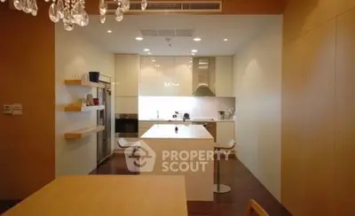 Modern kitchen with sleek cabinetry and central island in elegant apartment.