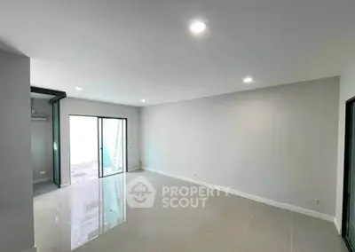 Spacious modern living room with large windows and sleek tile flooring