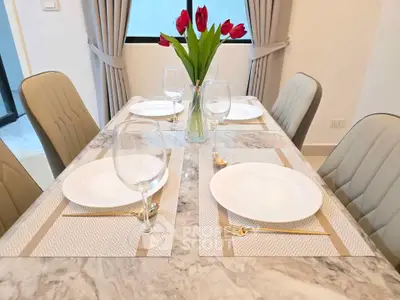 Elegant dining area with marble table and tulip centerpiece