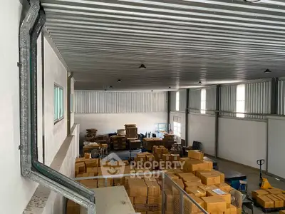 Spacious warehouse interior with stacked boxes and industrial lighting, ideal for storage and logistics operations.