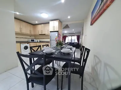 Spacious open-layout kitchen and dining area with modern appliances and elegant dining set.