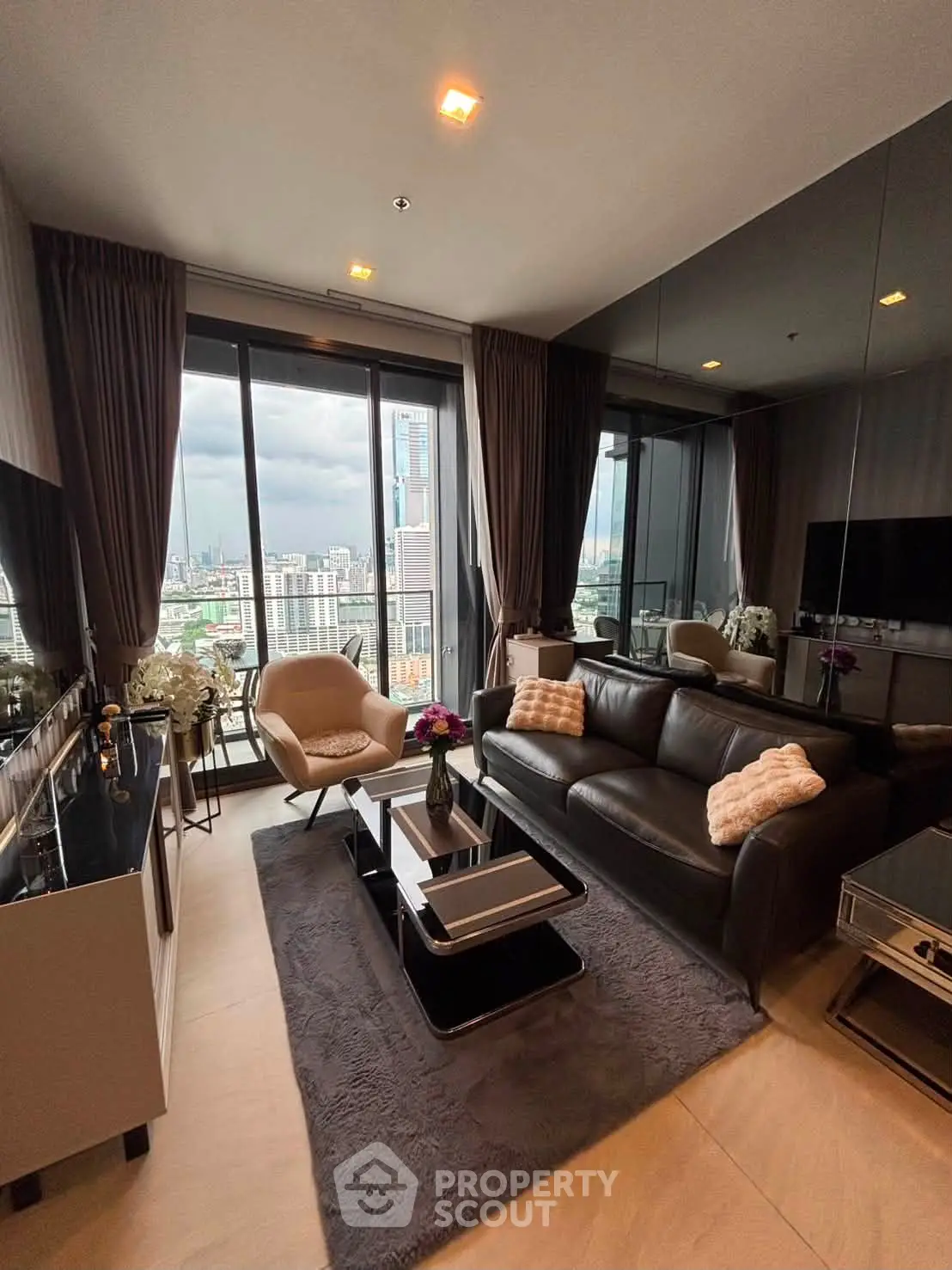 Luxurious living room with city view, elegant decor, and modern furnishings in high-rise apartment.