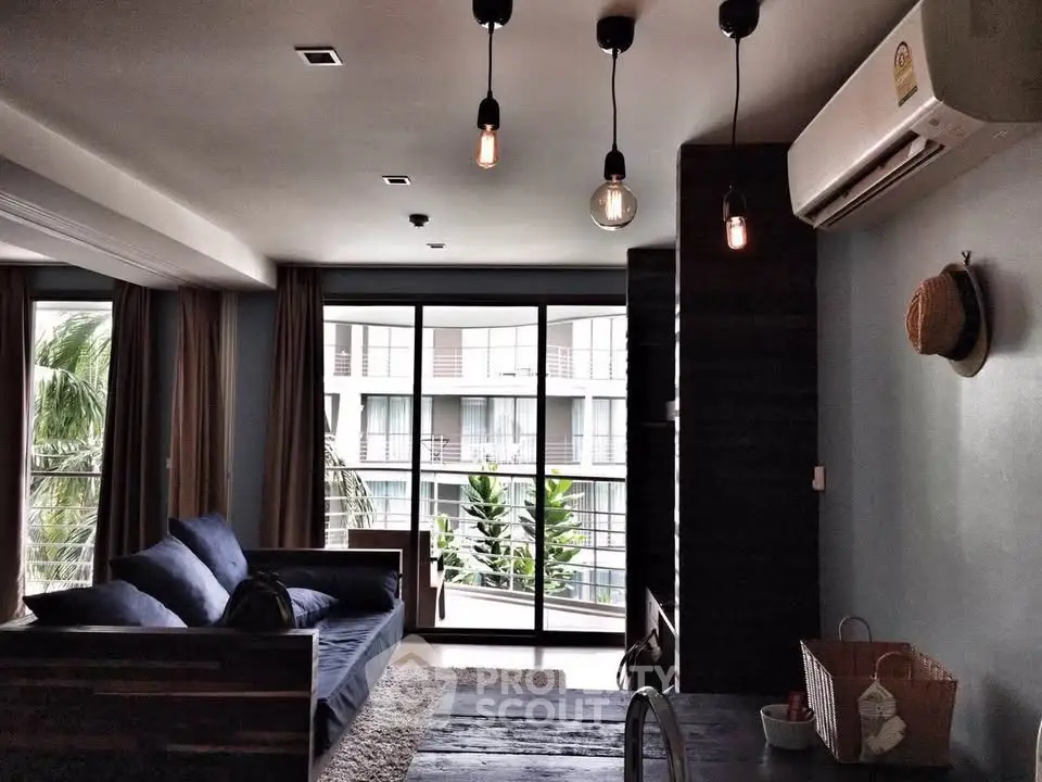 Stylish living room with modern lighting and large windows overlooking a lush garden view.