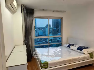 Modern bedroom with city view, featuring a comfortable bed and sleek furniture, perfect for urban living.