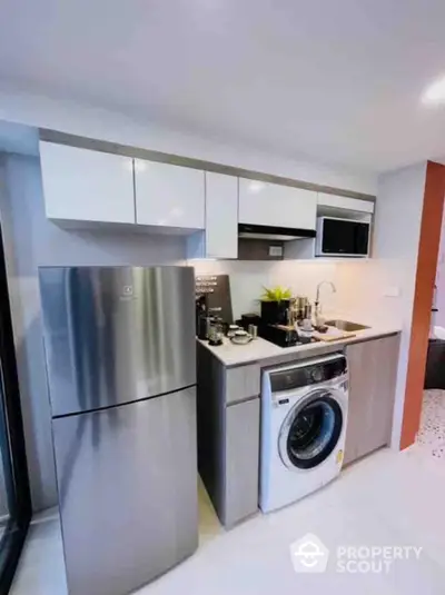 Modern kitchen with stainless steel appliances and compact design.