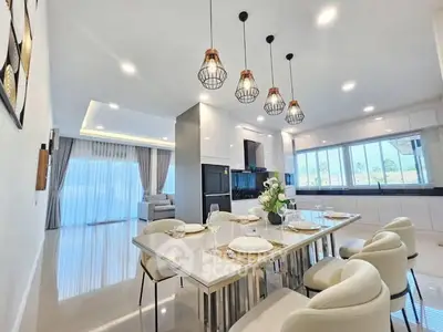 Luxurious open-layout kitchen and dining area with modern lighting and elegant decor.