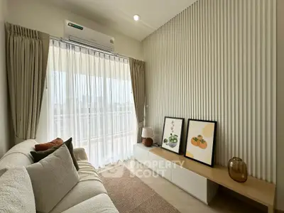 Modern living room with cozy sofa, stylish decor, and large window with balcony view.