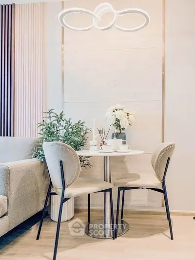 Modern dining area with elegant chairs and stylish lighting in a cozy living space.