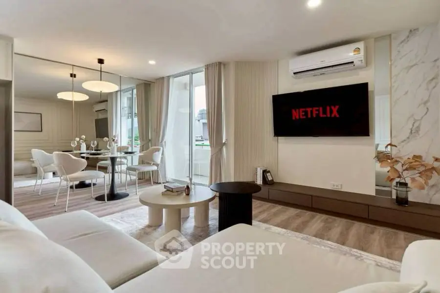 Modern living room with open layout, stylish furniture, and wall-mounted TV for ultimate comfort.