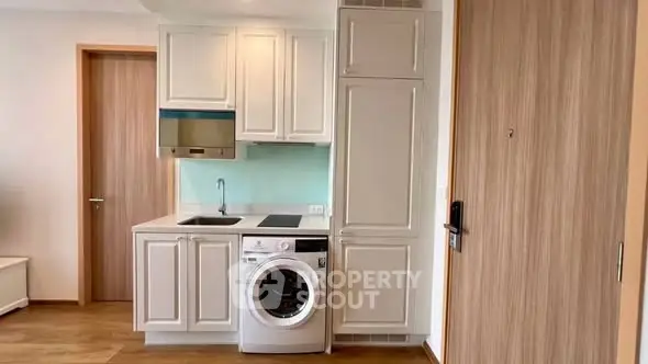 Compact kitchen with integrated washing machine and modern cabinetry