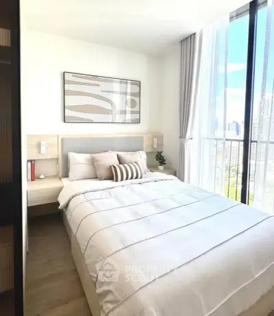 Bright and modern bedroom with large window and stylish decor in urban apartment.