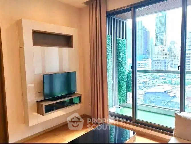 Modern living room with city view and sleek TV setup in high-rise apartment.