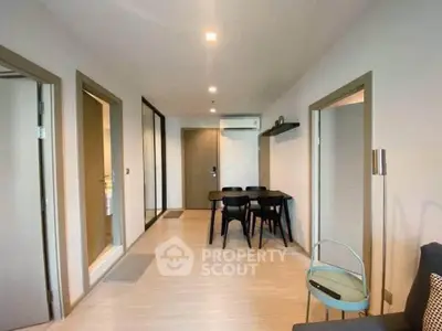 Modern apartment interior with dining area and hallway, featuring sleek design and neutral tones.