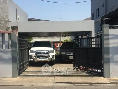Spacious residential parking area with two cars in a secure gated driveway.