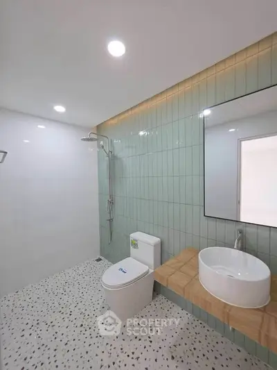 Modern bathroom with sleek design, featuring a walk-in shower and stylish fixtures.