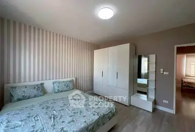 Modern bedroom with stylish decor and ample storage in a cozy apartment.