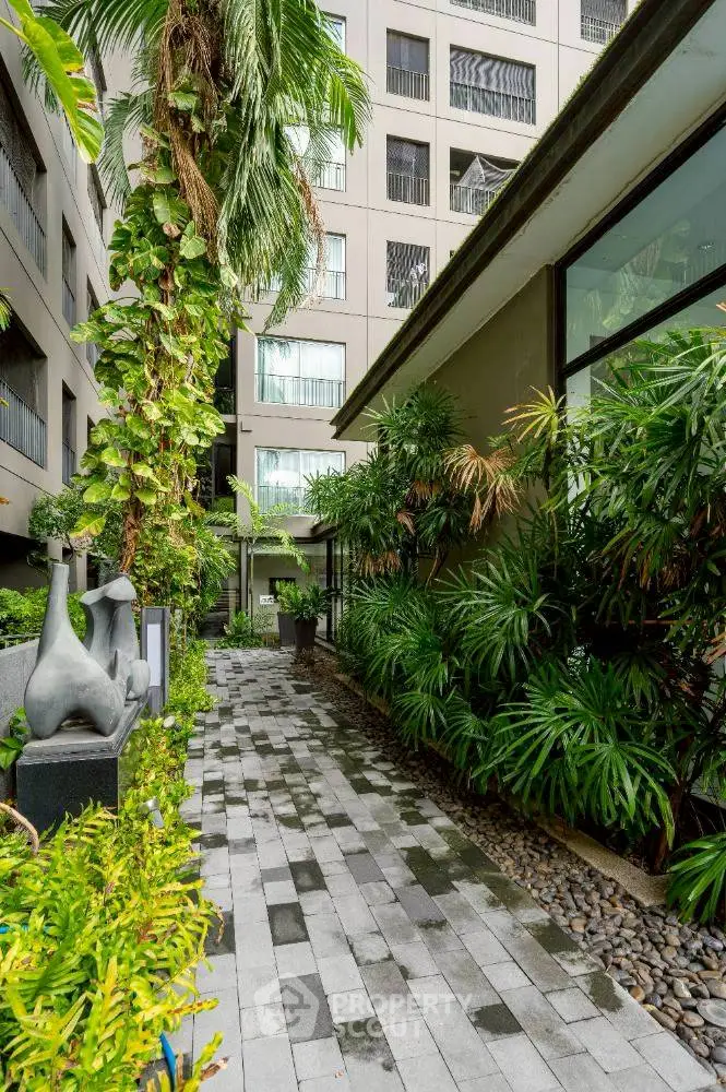 Modern apartment building with lush greenery and stylish pathway