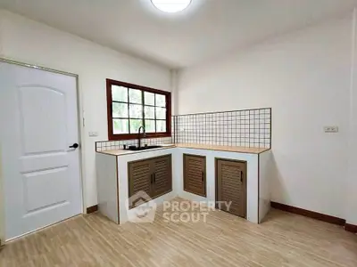 Modern kitchen with closed layout and wooden cabinets in a bright, minimalist design.