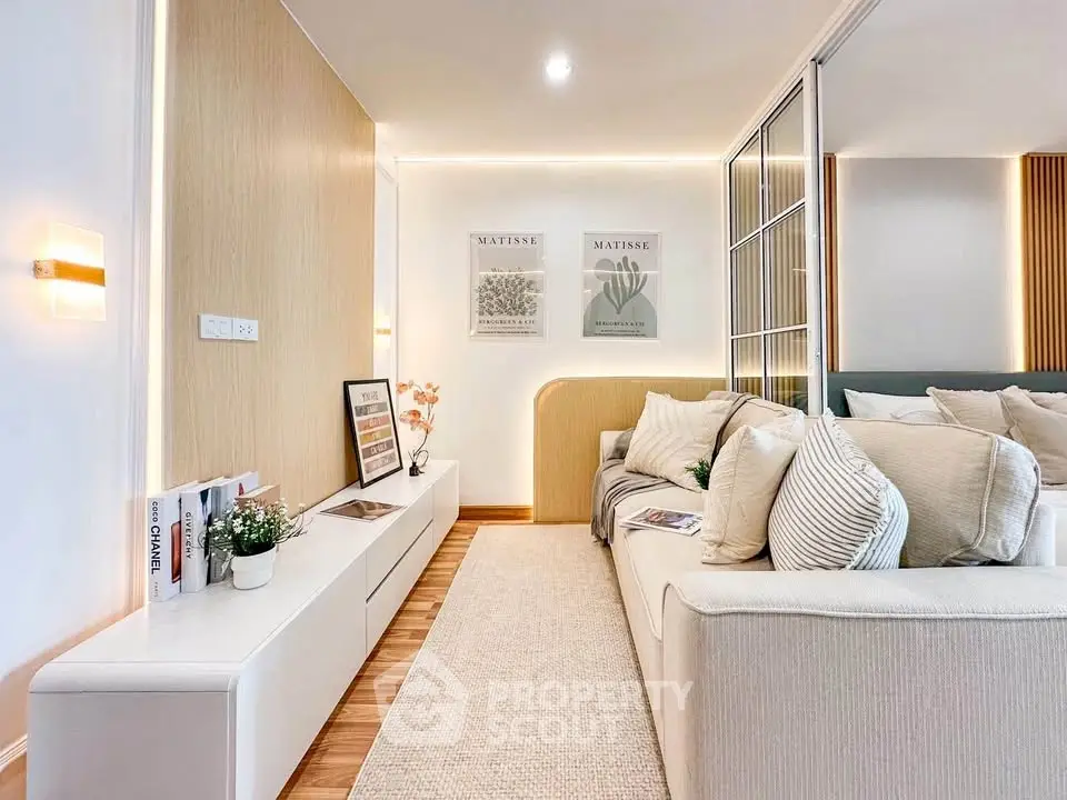 Modern living room with stylish decor and cozy seating area, featuring elegant lighting and art pieces.