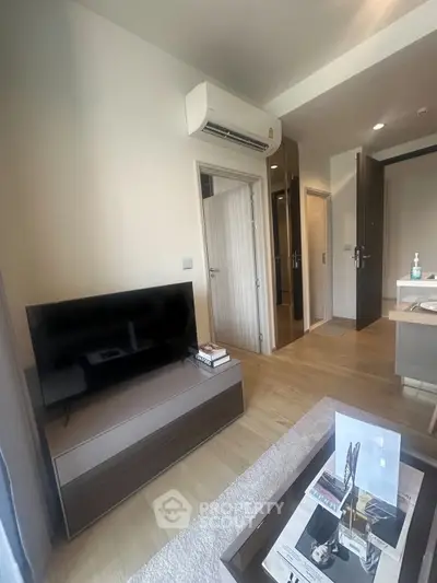 Modern living room with sleek TV setup and stylish decor in a contemporary apartment.