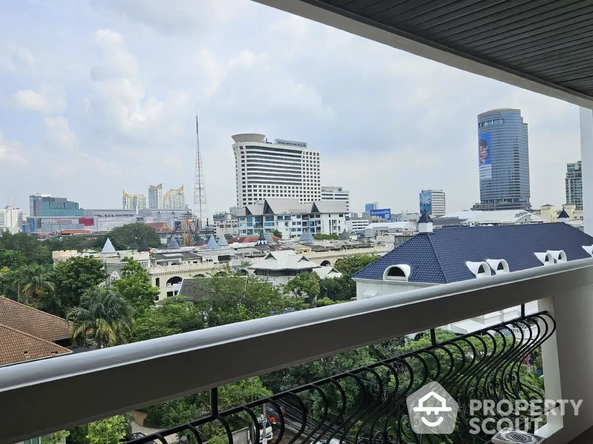 Stunning cityscape view from a modern balcony overlooking urban skyline and lush greenery.