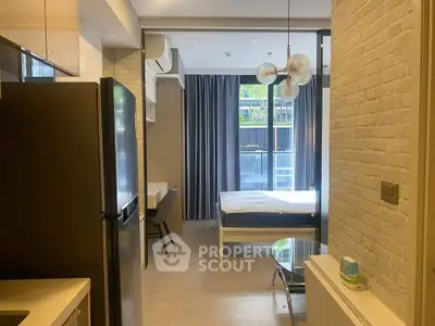 Modern studio apartment with open layout, featuring a sleek kitchen and cozy living area.