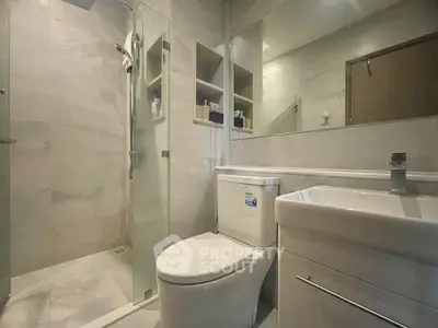 Modern bathroom with glass shower and sleek fixtures in a contemporary apartment.