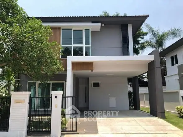 Modern two-story house with sleek design and spacious driveway in a serene neighborhood.