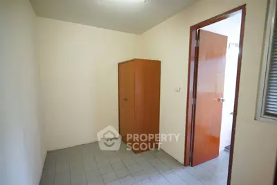 Compact storage room with wooden cabinet and tiled floor